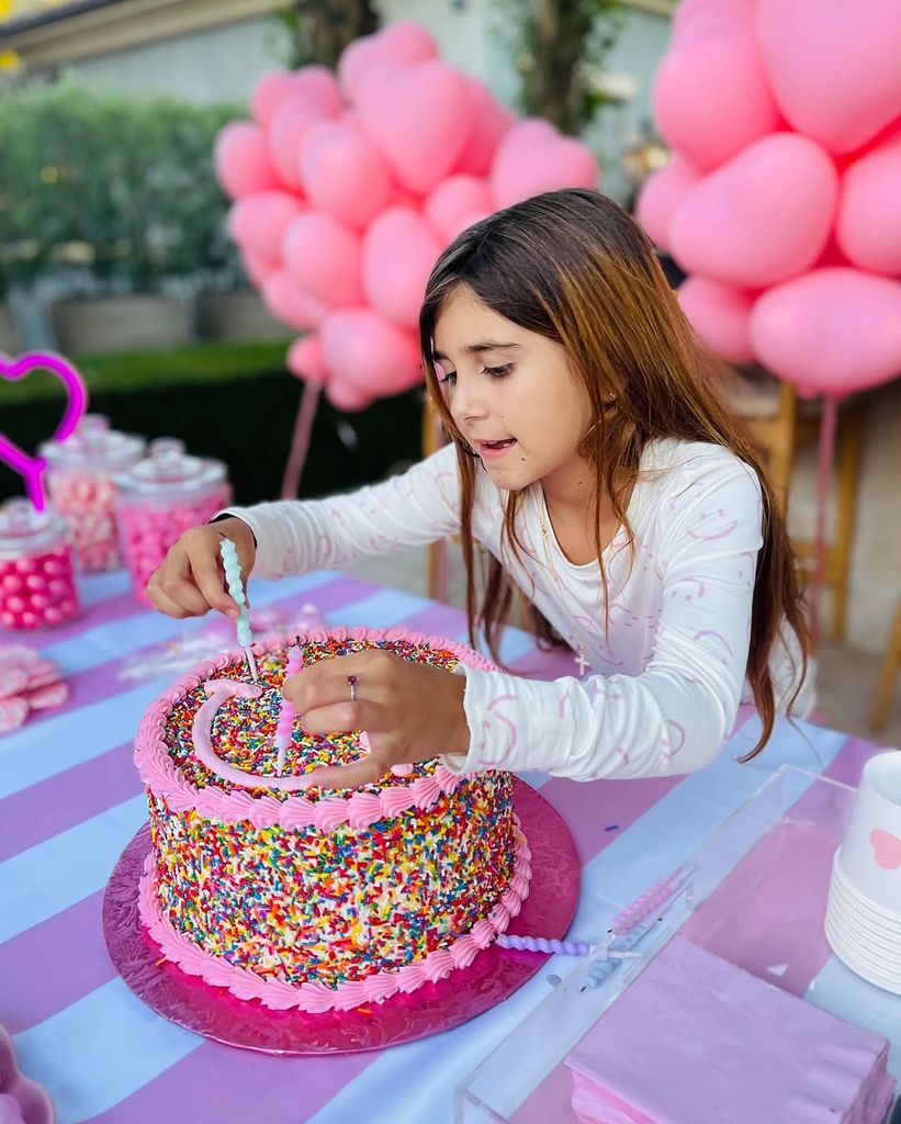 Kourtney Kardashian's daughter Penelope sits in front of a confetti cake