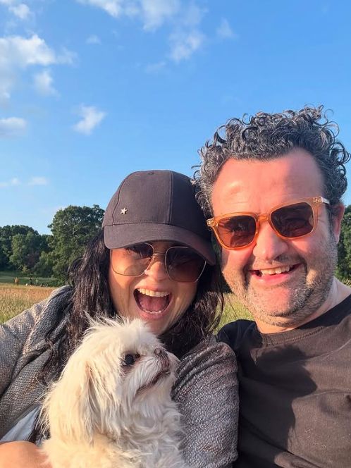 Daniel Mays with his wife and white dog in a field