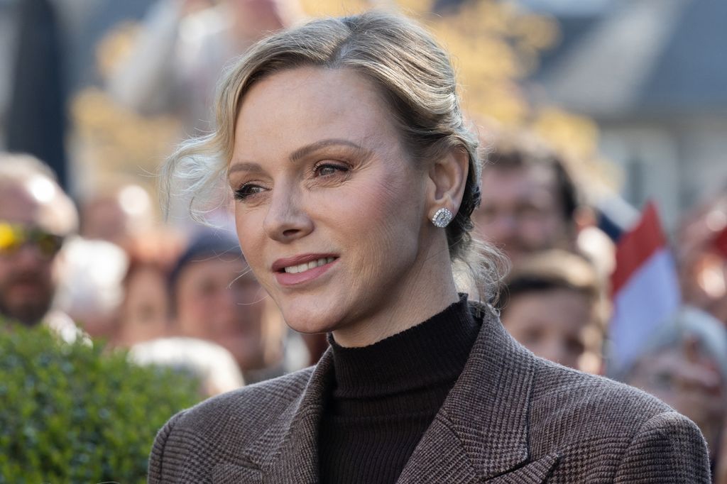 princess charlene smiling in check suit 