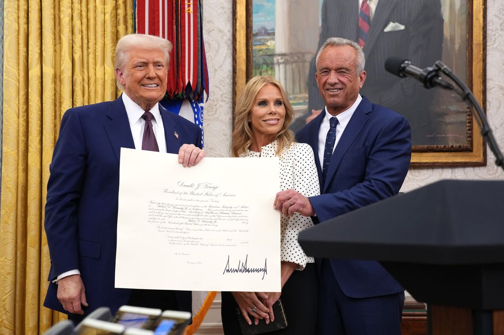 President Donald Trump, Robert F. Kennedy Jr., and Kennedy's wife Cheryl Hines pose after Kennedy was sworn in as Secretary of Health and Human Services in the Oval Office