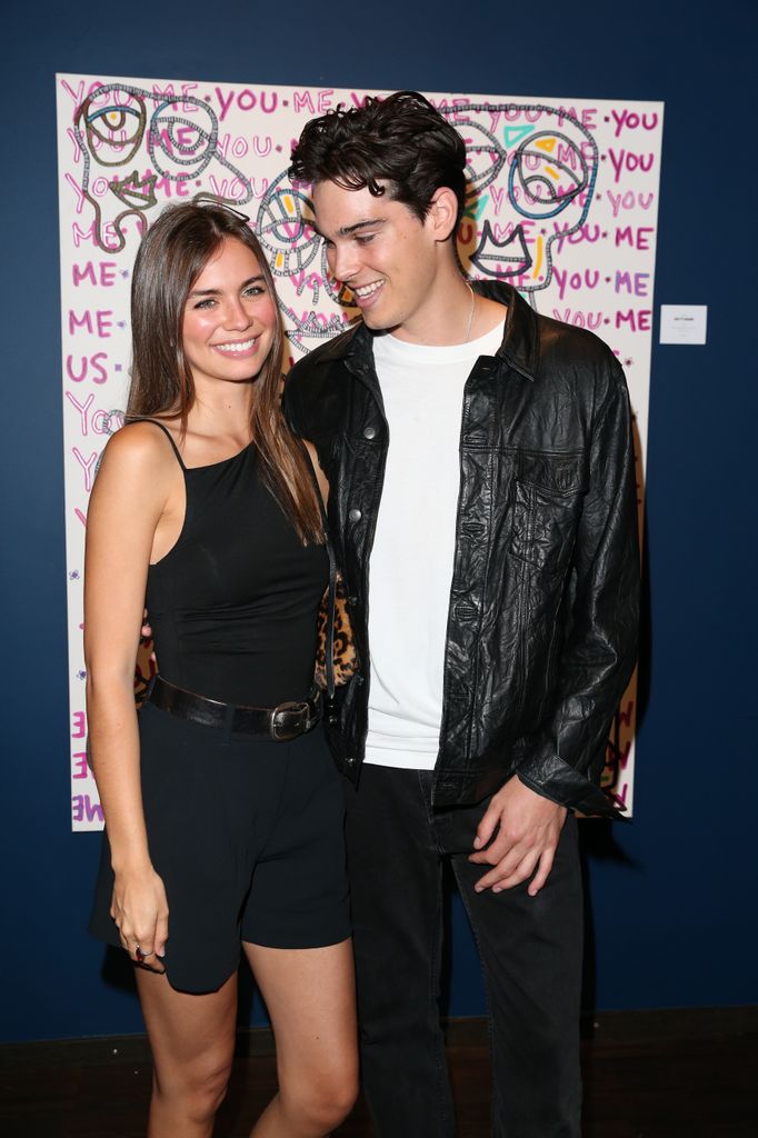 paris brosnan posing for photo with girlfriend alex lee aillon in front of his painting