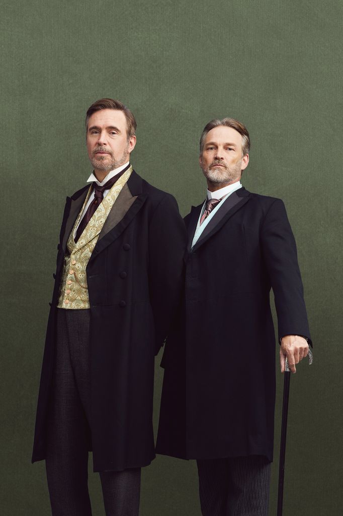 two men in period suits against green background