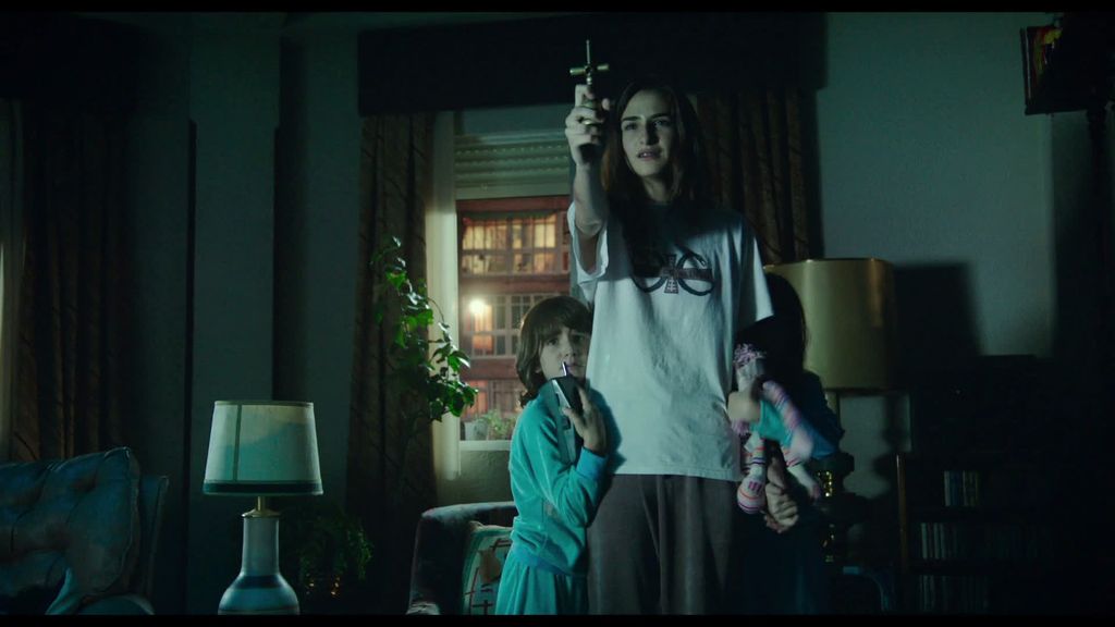 Veronica holding a crucifix with two young children