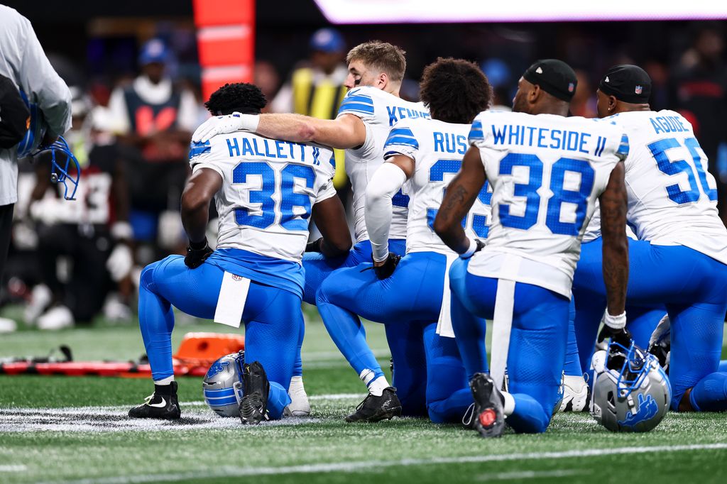 Tom Kennedy #85 of the Detroit Lions puts his arm around Erick Hallett #36 after Morice Norris #26 sustained an injury 