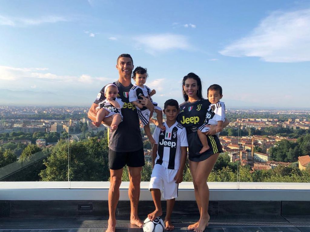 A family of six standing on a balcony