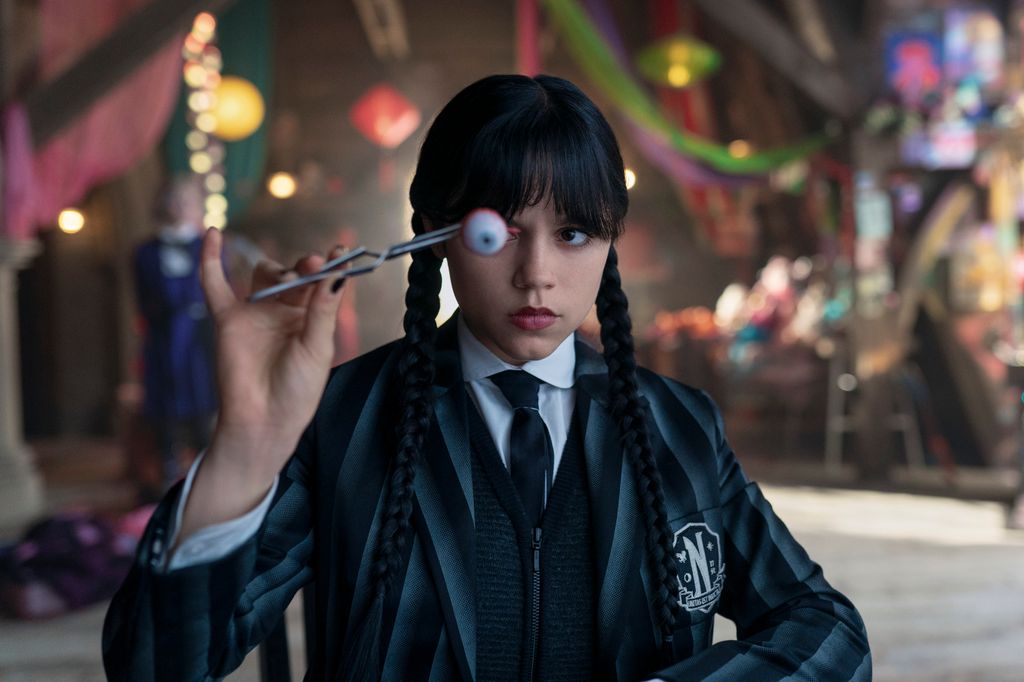 young girl dressed in black holding eye ball
