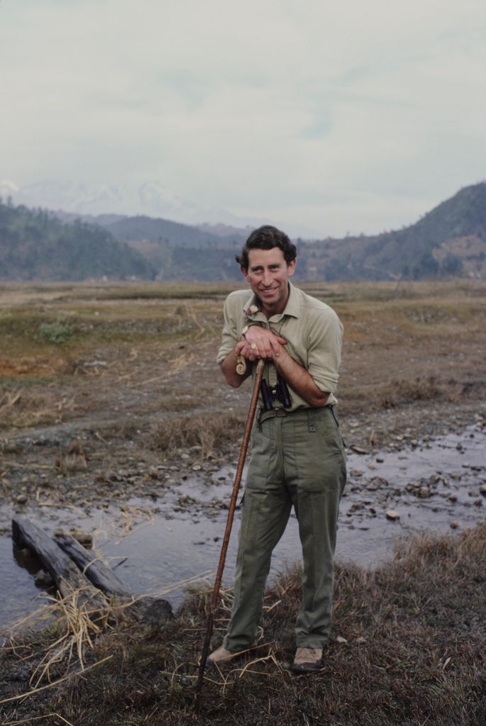 King Charles in the mountains with a walking stick