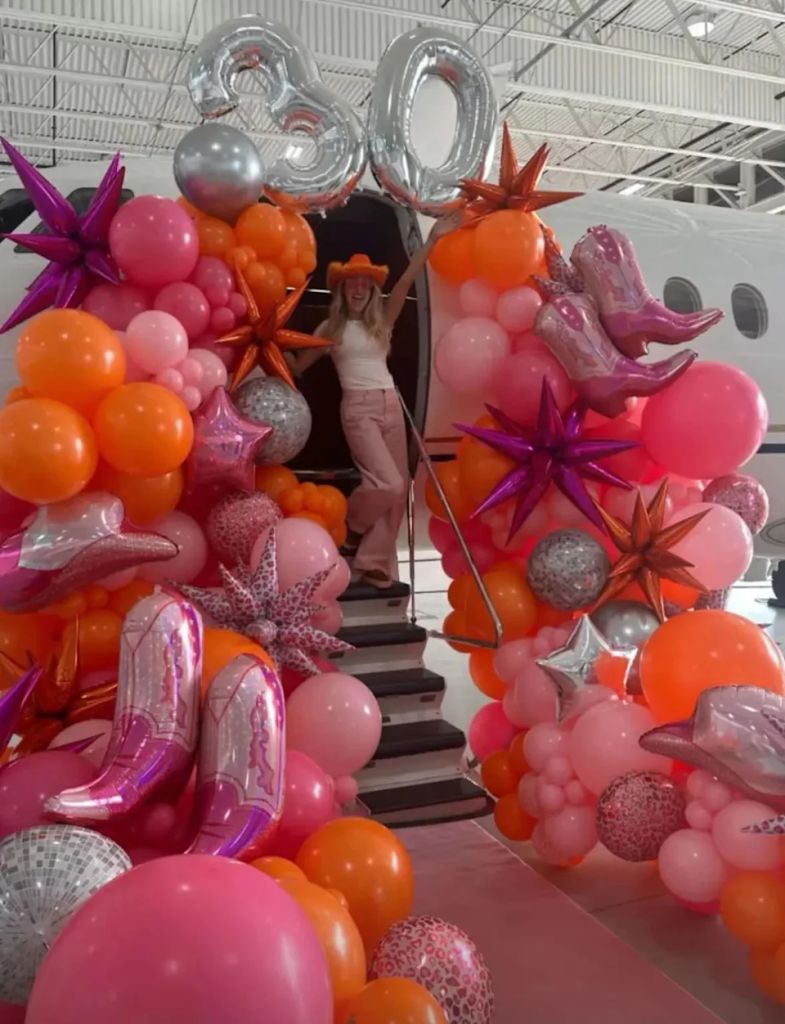 Brittany Mahomes at the top of the stairs entering a jet 