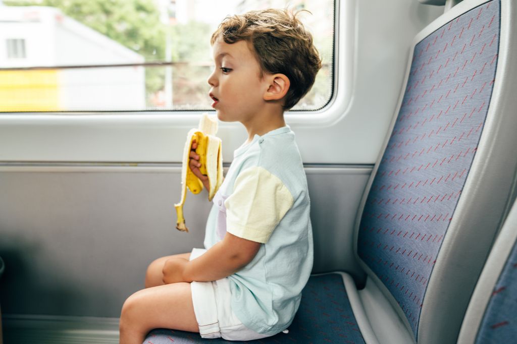 boy eating banana on train
