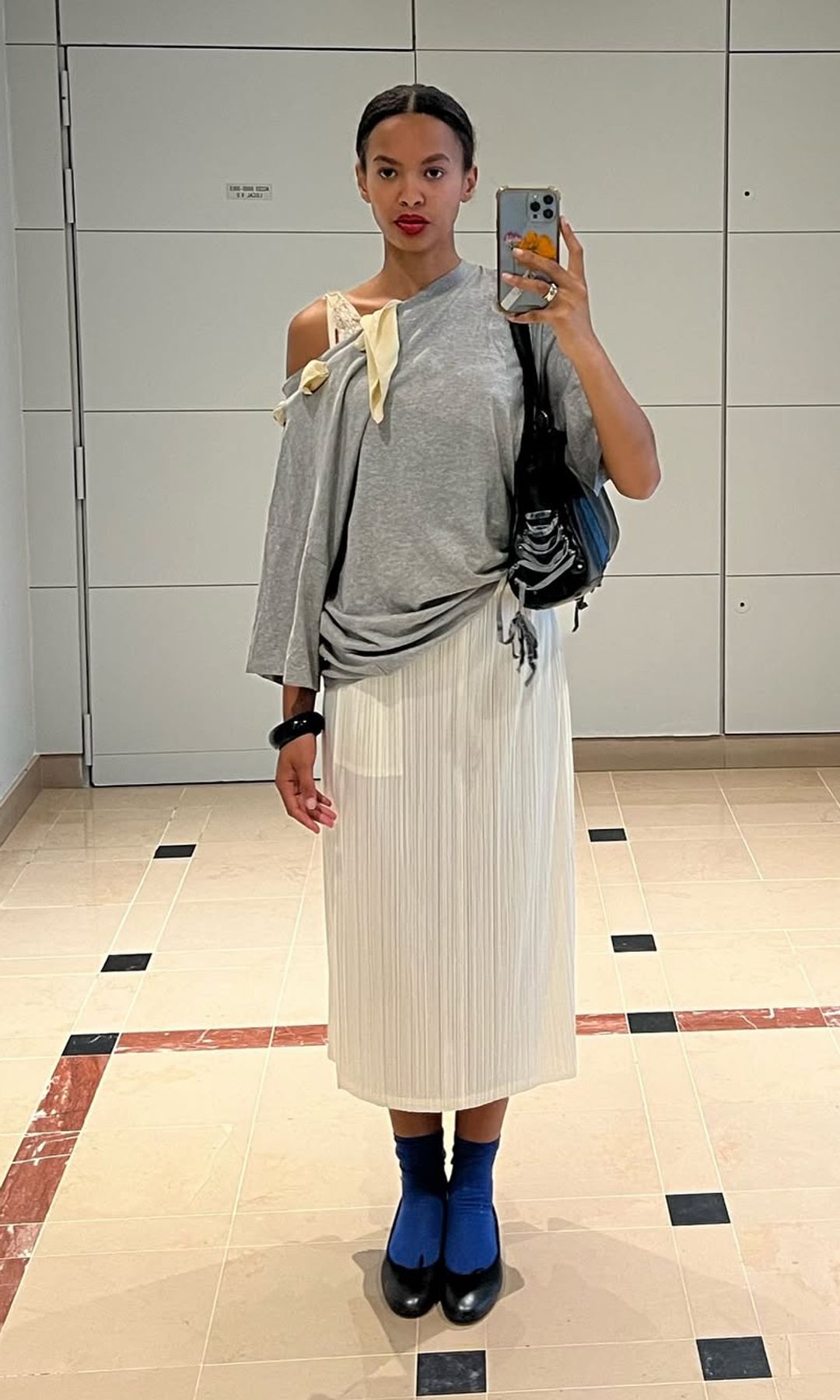 rosie okotcha in pleated white skirt
