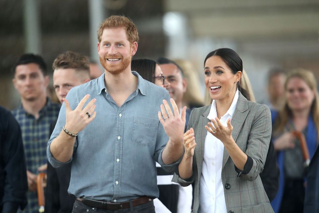 Prince Harry, Duke of Sussex and Meghan talking with hands held out