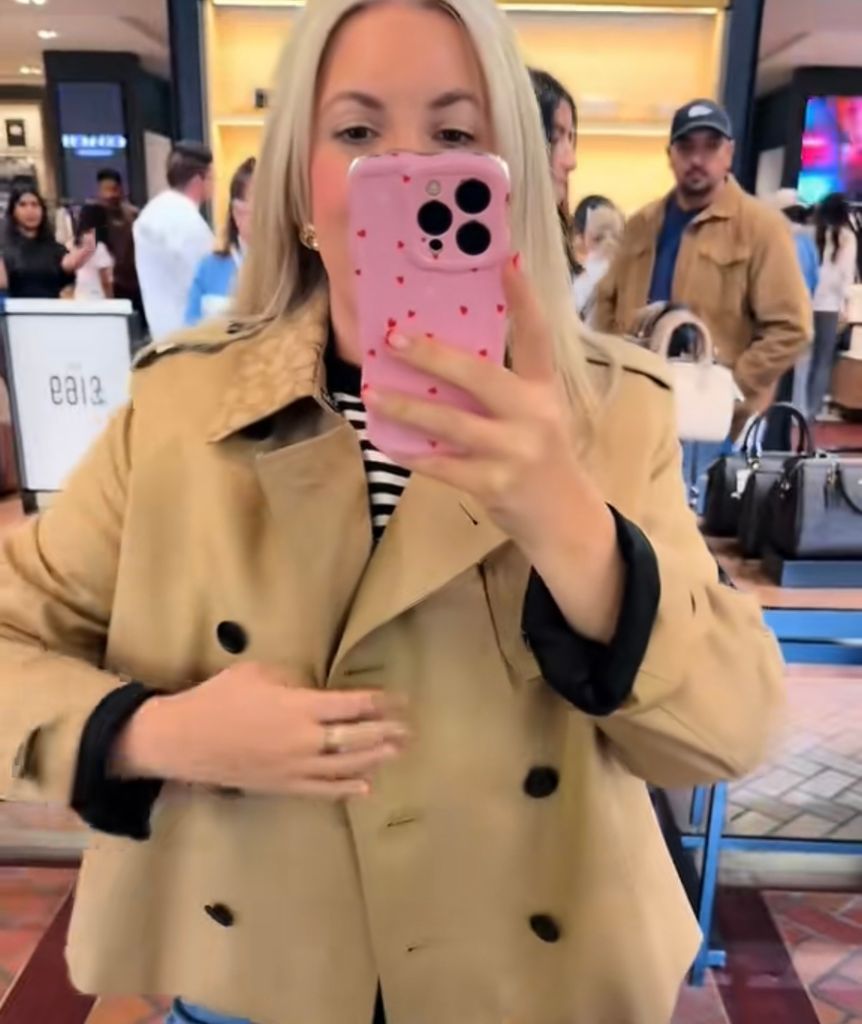Leanne Bayley wearing a cropped coach trench coat while shopping at bicester village