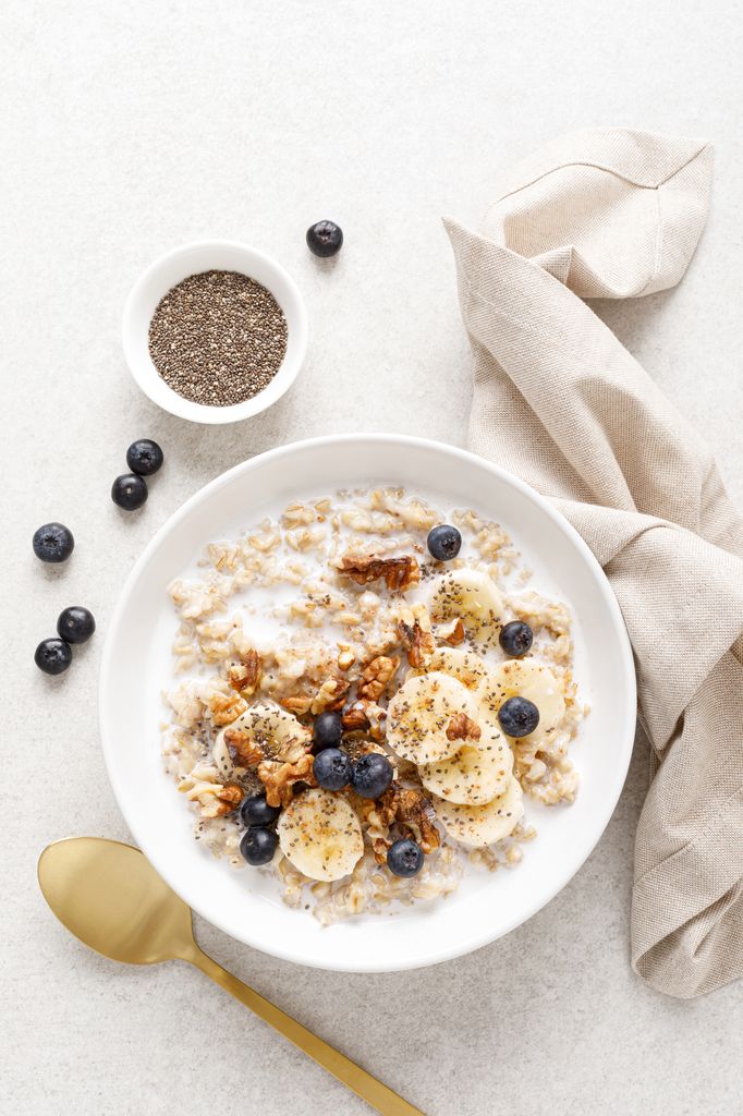 Oatmeal bowl. Oat porridge with banana, blueberry, walnut, chia seeds and almond milk for healthy breakfast or lunch. Healthy food, diet. Top view.