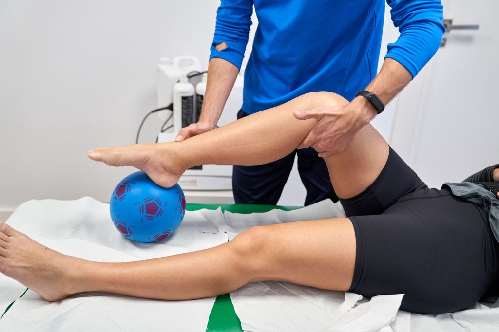 Physiotherapist man helping in the recovery of a female patient 
