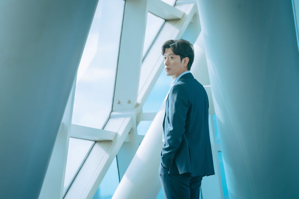 man standing next to window