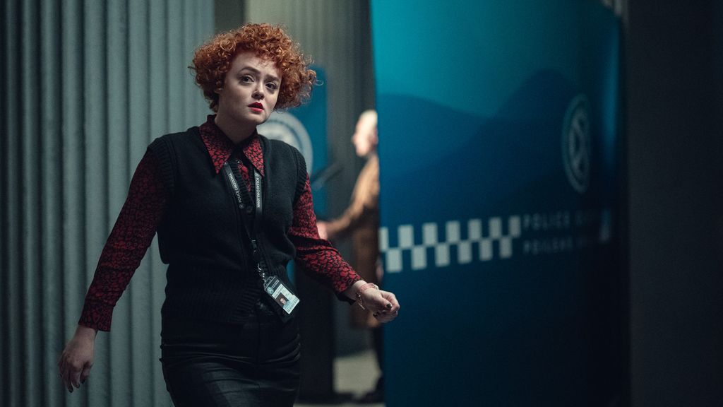woman with red hair wearing police lanyard