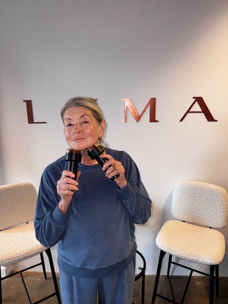 Martha posing with the LYMA Laser PRO device in blue sweatpants