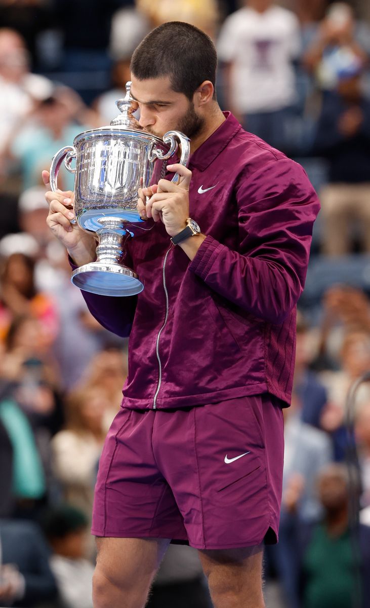 Carlos Alcaraz kisses the trophy after capturing the 2025 US Open title, his emotions pouring out following his win over Jannik Sinner.