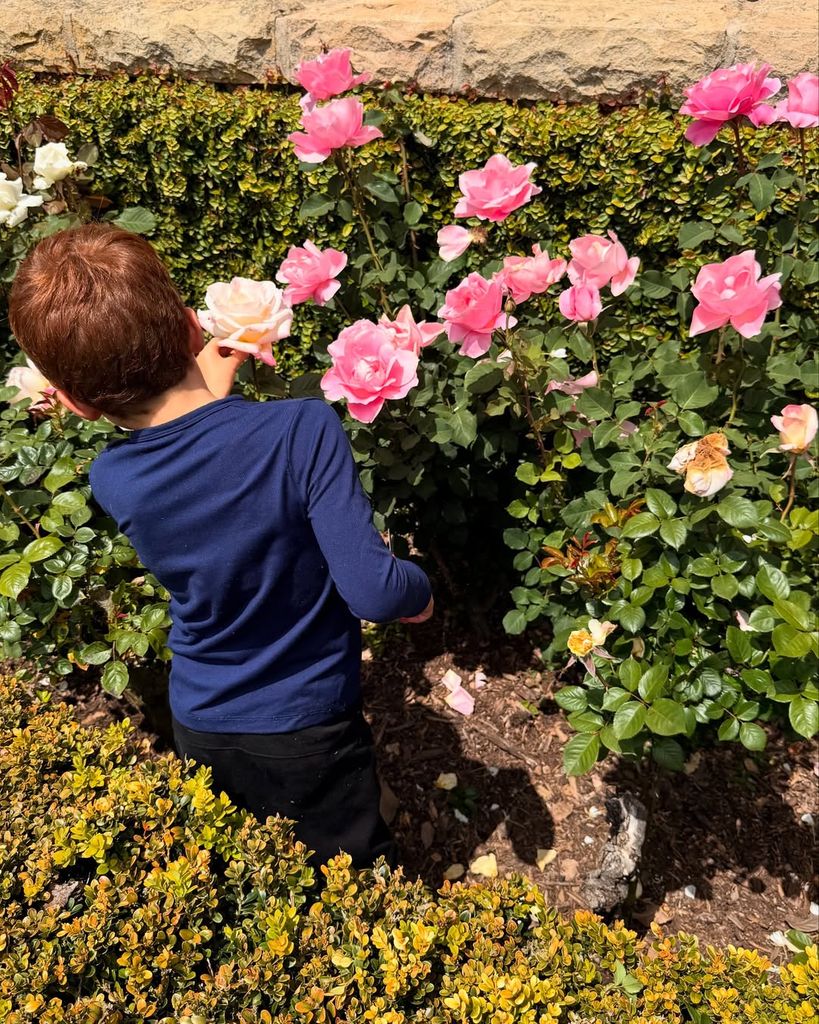 Prince Archie Harrison tends to a rose in a photo captured by Meghan Markle in their garden