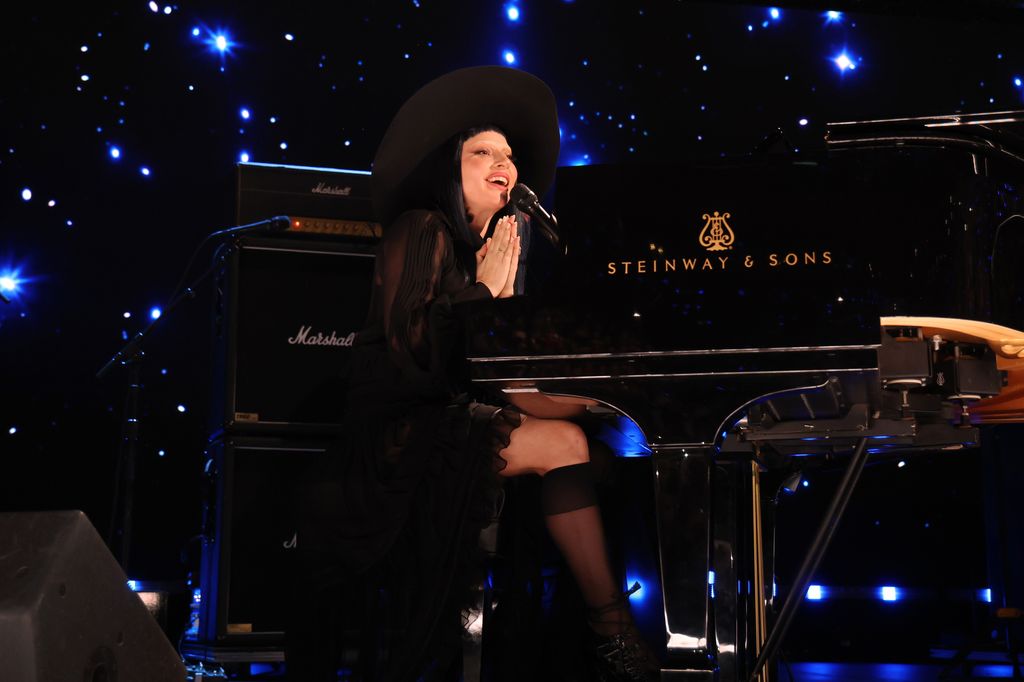 lady gaga sitting at black piano fireaid concert