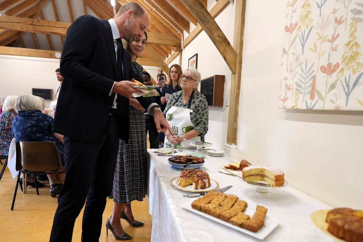 SUNNINGDALE, ENGLAND - SEPTEMBER 8: Catherine, Princess of Wales and Prince William, Prince of Wales choose a cake as they visit the National Federation of Women's Institute (WI) to commemorate the three-year anniversary of the death of Queen Elizabeth II on September 8, 2025 in Sunningdale, England. (Photo by Alastair Grant - WPA Pool/Getty Images)