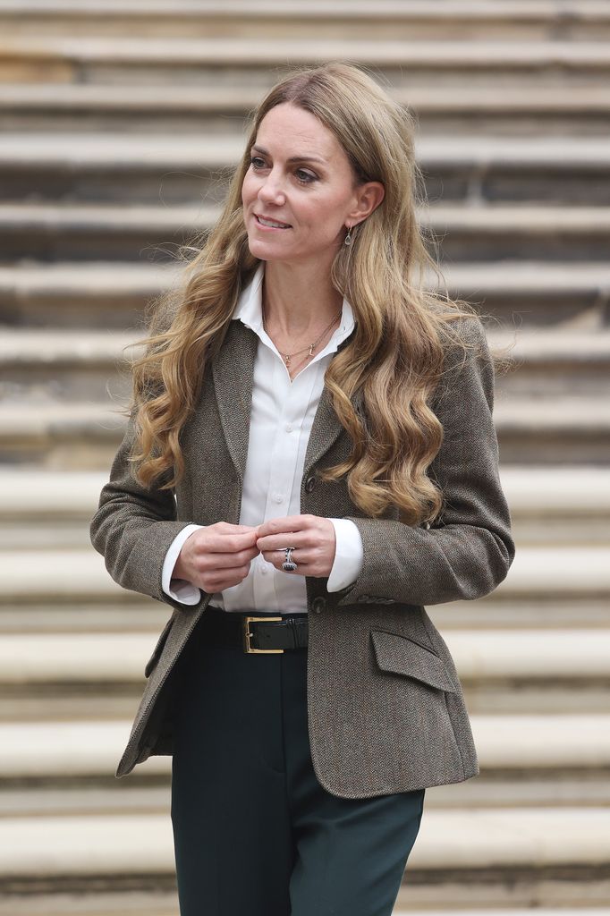 Catherine, Princess of Wales walking outside in brown blazer and black trousers