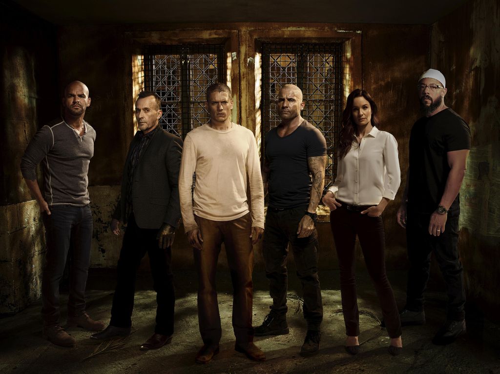 group of people standing in dark prison cell