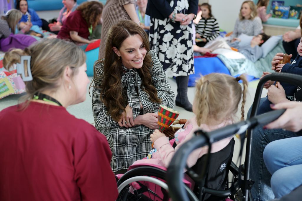 Kate smiling at little girl at children's hospice