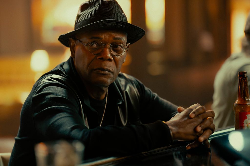 man sitting at bar in black hat