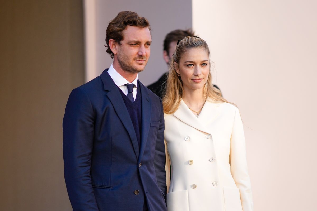  Pierre Casiraghi (L) wears a white shirt, a navy blue tie, a navy blue wool V-neck pullover, a navy blue blazer jacket, ; Beatrice Borromeo (R) wears earrings, a gold chain pendant necklace, a white t-shirt, a white latte buttoned jacket, outside Dior during Paris Fashion Week