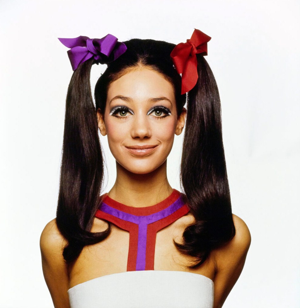 Marisa Berenson smiling with her hair in pigtails 