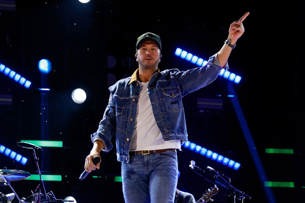 photo of luke bruan on stage with arm in the air