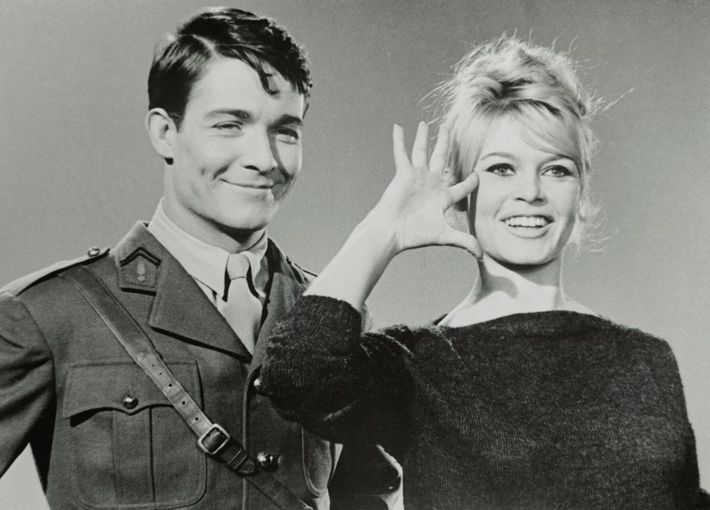 Slated to become a war heroine, on the screen that is, French movie actress Brigitte Bardot previews with a salute her role in the forthcoming film, Babette Goes to War. She will play a resistance fighter, with actor Jacques Charrier, left, portraying a dashing free French officer. Shooting is scheduled to start in January.