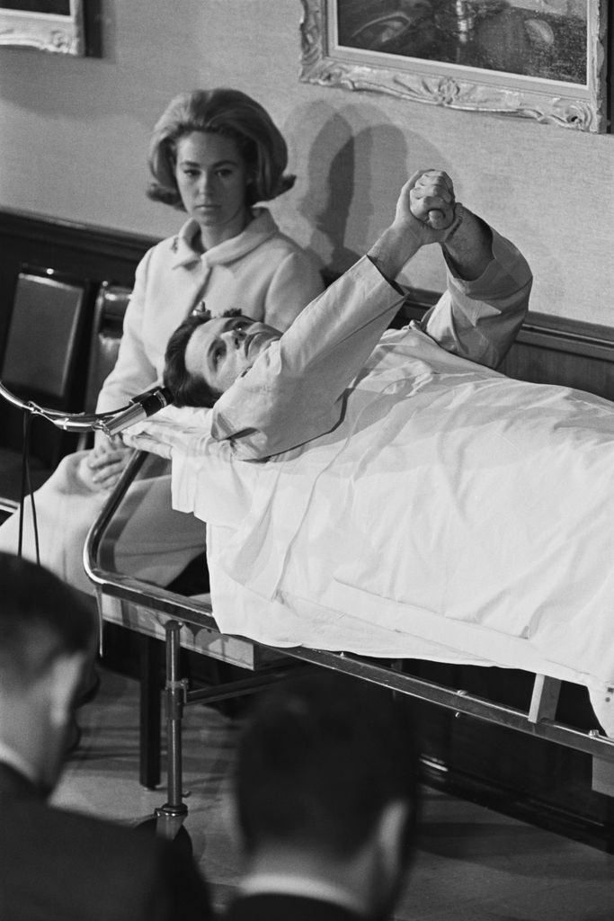 Joan Kennedy sits beside her husband, Senator Ted Kennedy, who broke his back in a plane crash in June 1964.