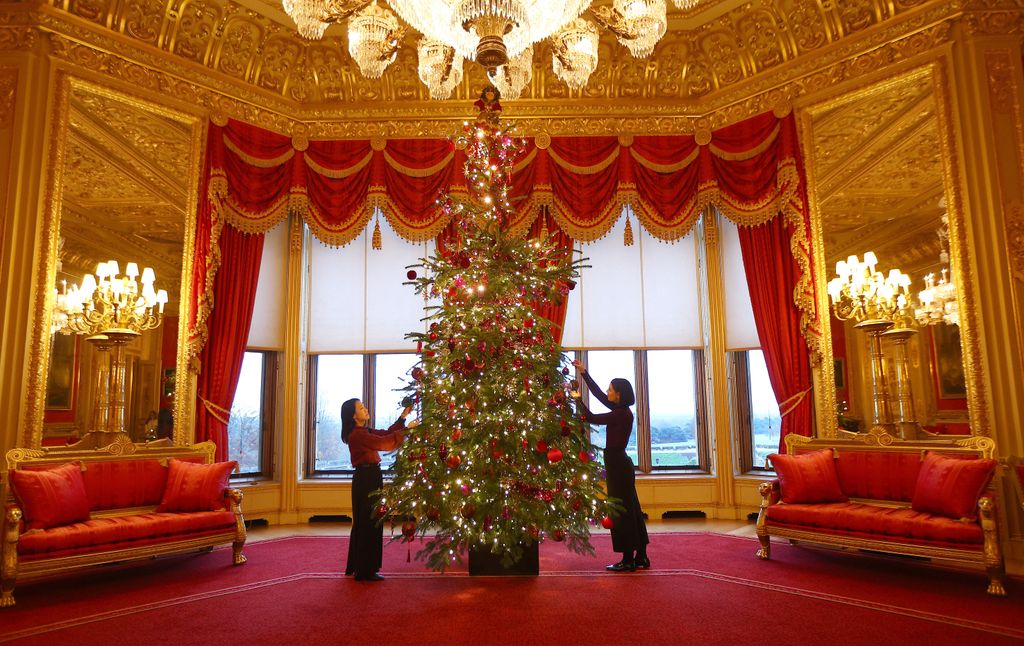 WINDSOR, ENGLAND - NOVEMBER 21: Royal household staff pose for a photograph next to a decorated Christmas tree at Windsor Castle on November 21, 2024 in Windsor, England. During this Christmas period, visitors to Windsor Castle will see festive displays decorate the state apartments and outside, including a 20-foot-high Nordmann Fir tree in St George's Hall, grown nearby in Windsor Great Park and illuminated with thousands of lights.  (Photo by Peter Nicholls/Getty Images)