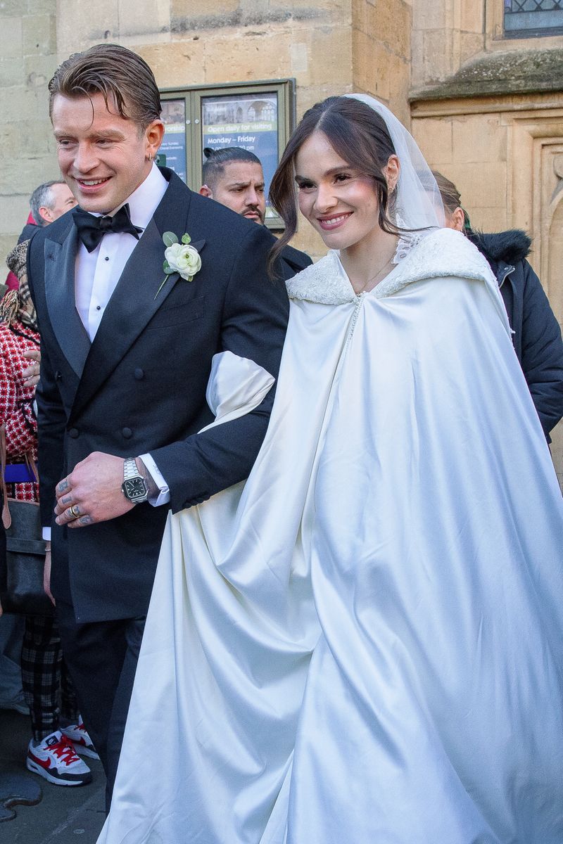 Holly, daughter of celebrity chef Gordon Ramsay, arrived at the historic church escorted by her father, wearing a flowing satin gown with lace trim and a dramatic ivory cape. 