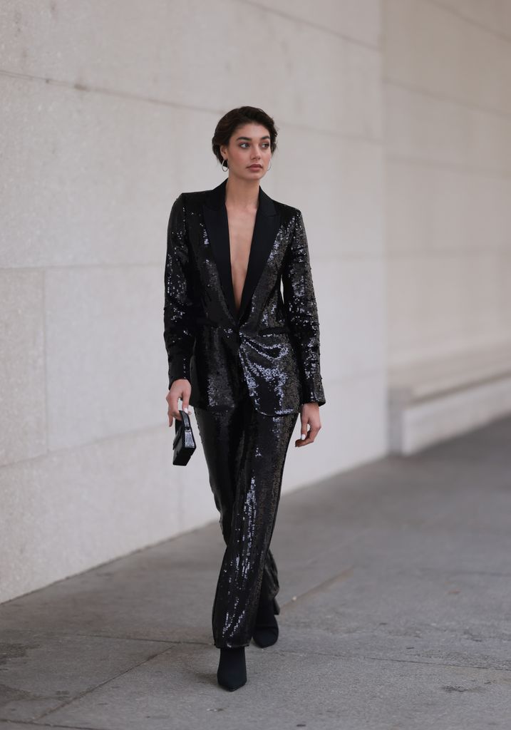 arah Posch seen wearing silver earrings, Karl Lagerfeld black sequins blazer jacket, matching Karl Lagerfeld black sequins long suit pants, Karl Lagerfeld black studded mini bag 