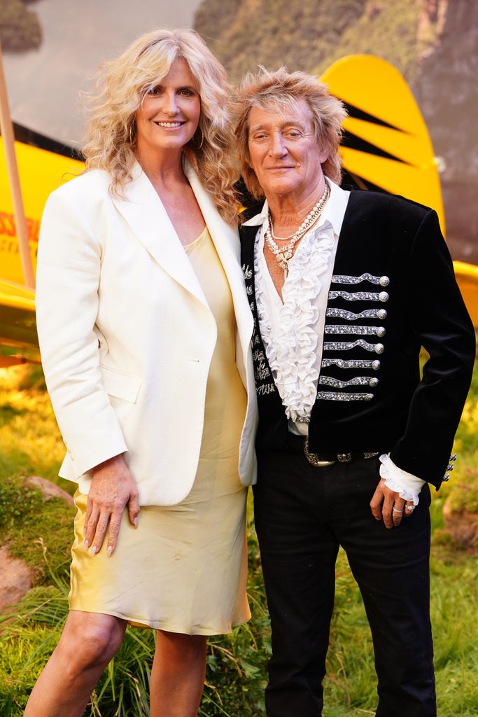 Penny Lancaster in yellow dress and white blazer and Sir Rod Stewart in frilled shirt and black jacket