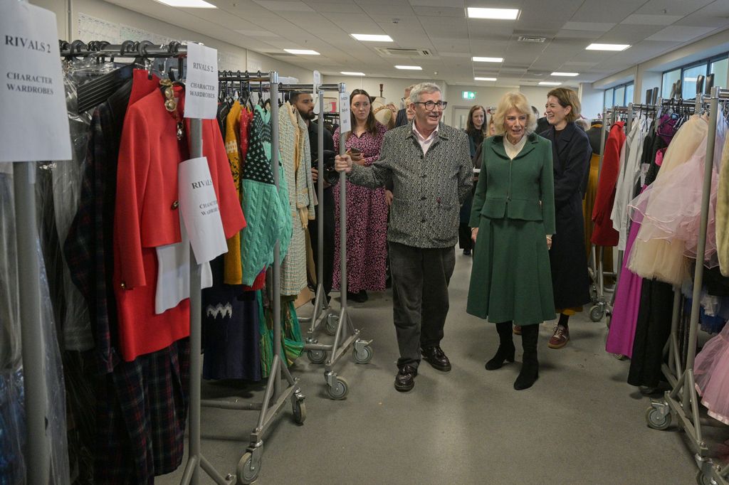 Queen Camilla views the costume department during a visit to the film set of TV Show 'Rivals' 