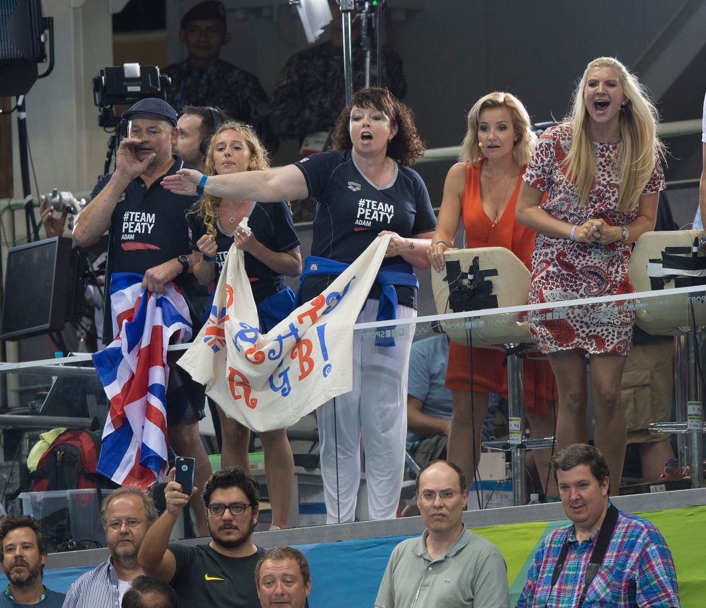 Adam Peaty's mum waving flag in stands at swimming stadium