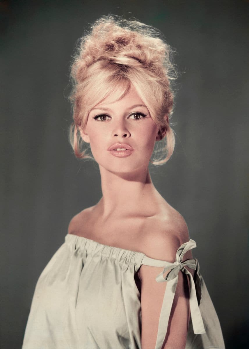 circa 1960:  Studio portrait of actor and model Brigitte Bardot wearing a light blue off-the-shoulder dress.