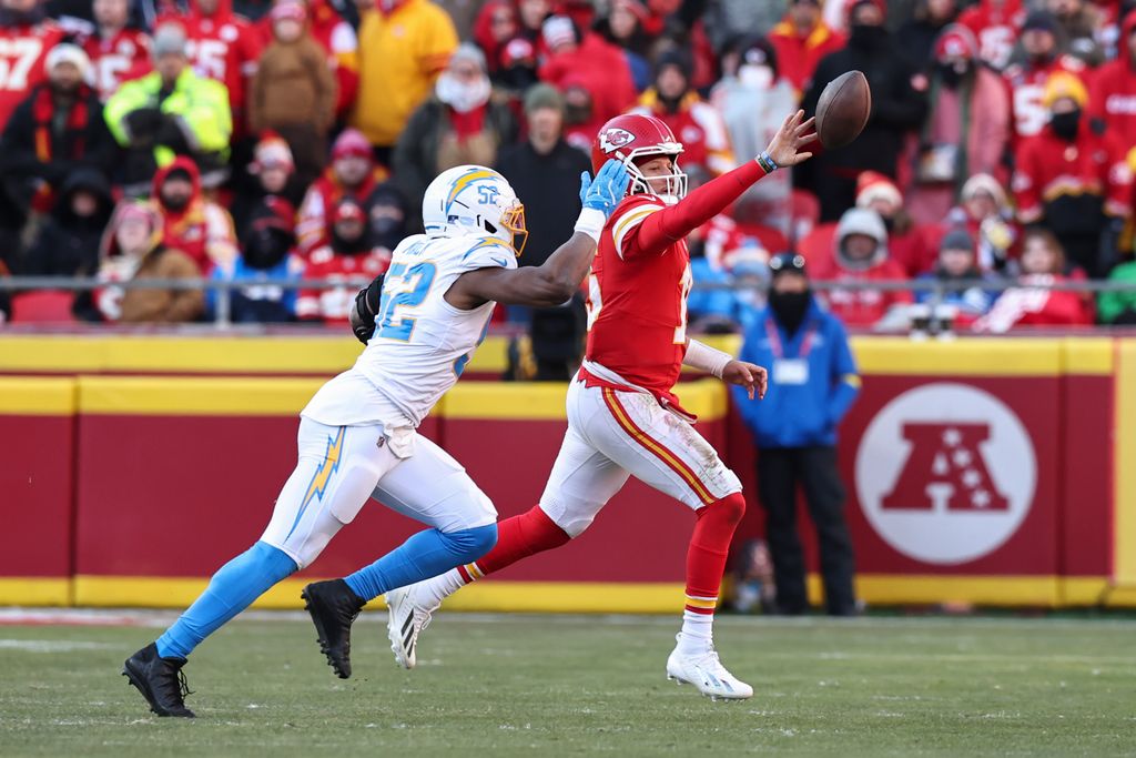 Kansas City Chiefs quarterback Patrick Mahomes (15) shovels a pass to avoid a sack by Los Angeles Chargers linebacker Khalil Mack (52) in the fourth quarter of an NFL game between the Los Angeles Chargers and Kansas City Chiefs on December 14, 2025 at GEHA Field at Arrowhead Stadium in Kansas City, MO.