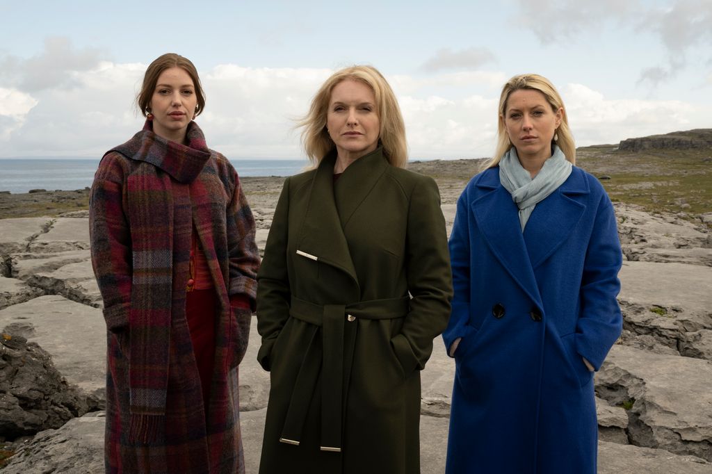 three women standing on rocks