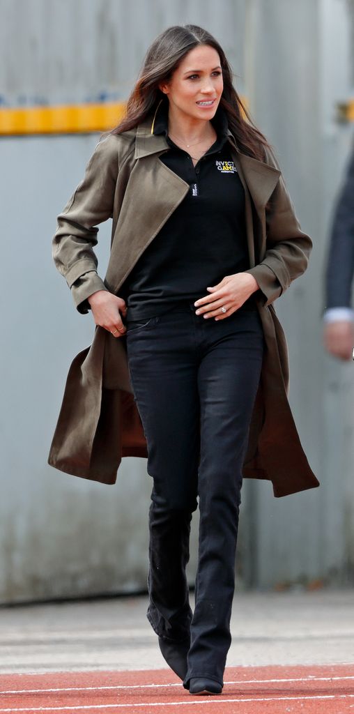 Meghan in black jeans and khaki trench coat