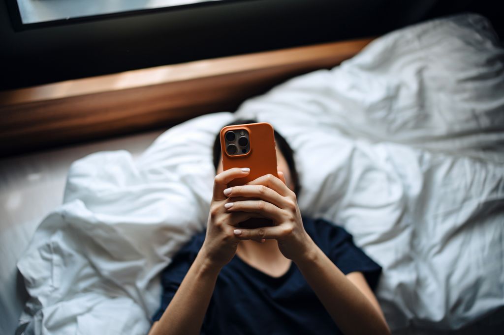 woman on phone in bed 