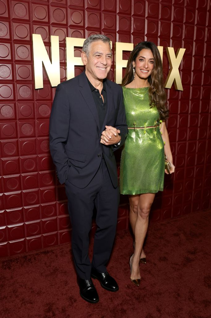 George Clooney and Amal Clooney in green mini dress smiling