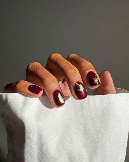 dark manicure with gold leaf accents