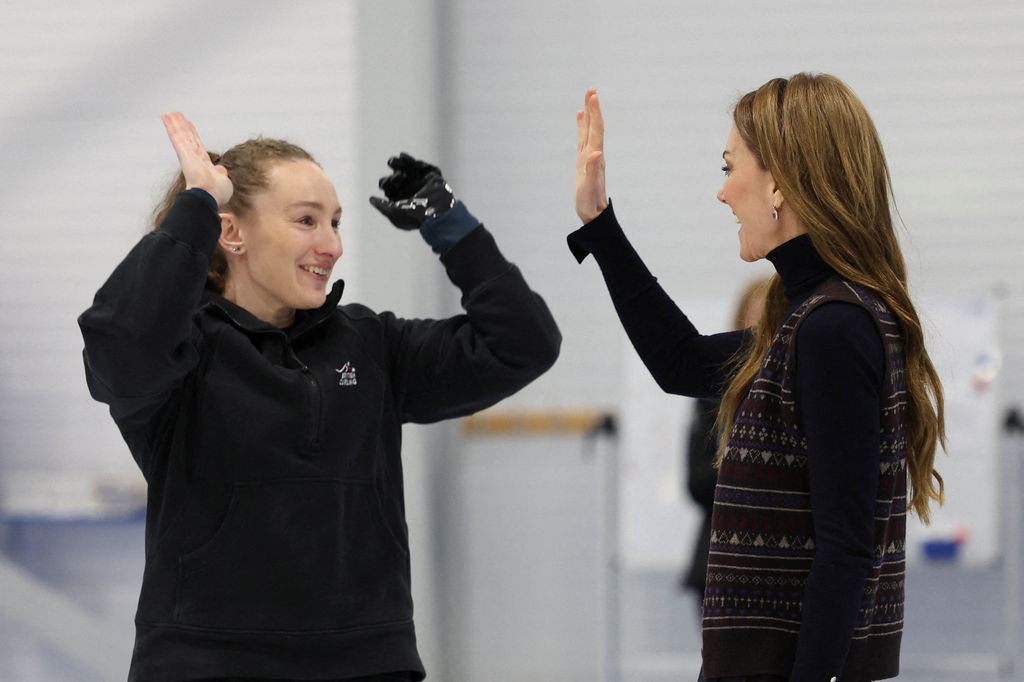 The Princess of Wales in fair isle waistcoat high fiving curling player