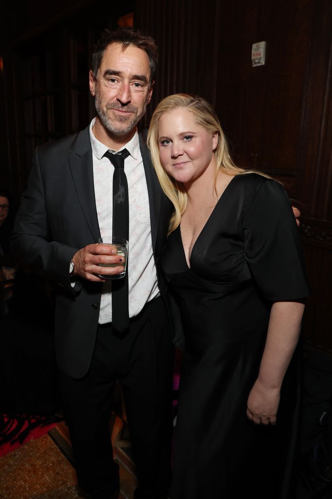 Chris Fischer in suit and Amy Schumer in black dress in February 2025