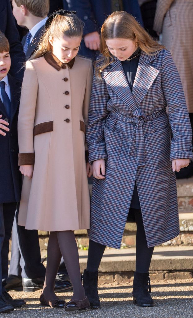 Princess Charlotte beside Mia Tindall after the Christmas Morning Service in coats